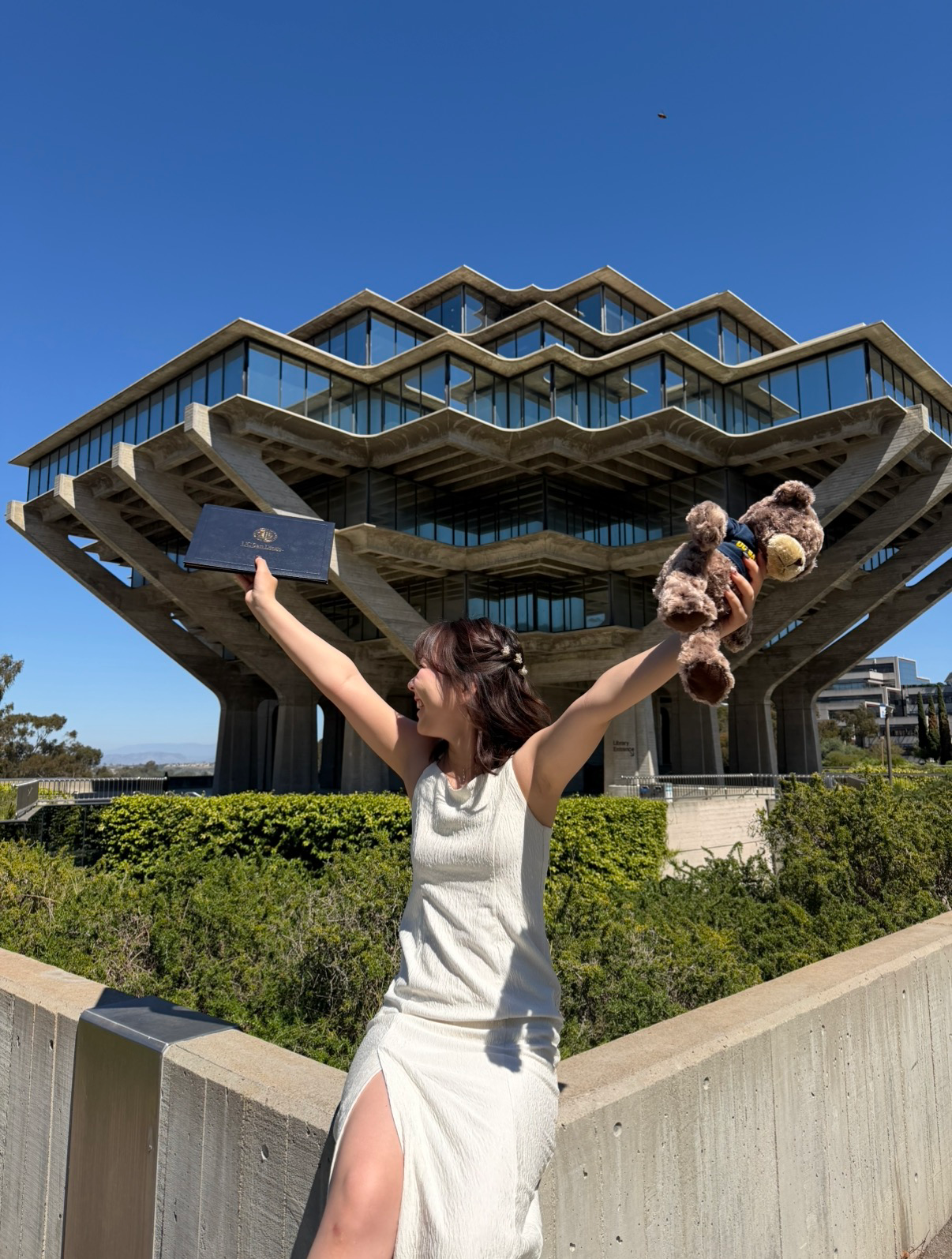 yumeka raising her arms in celebration in front of geisel library