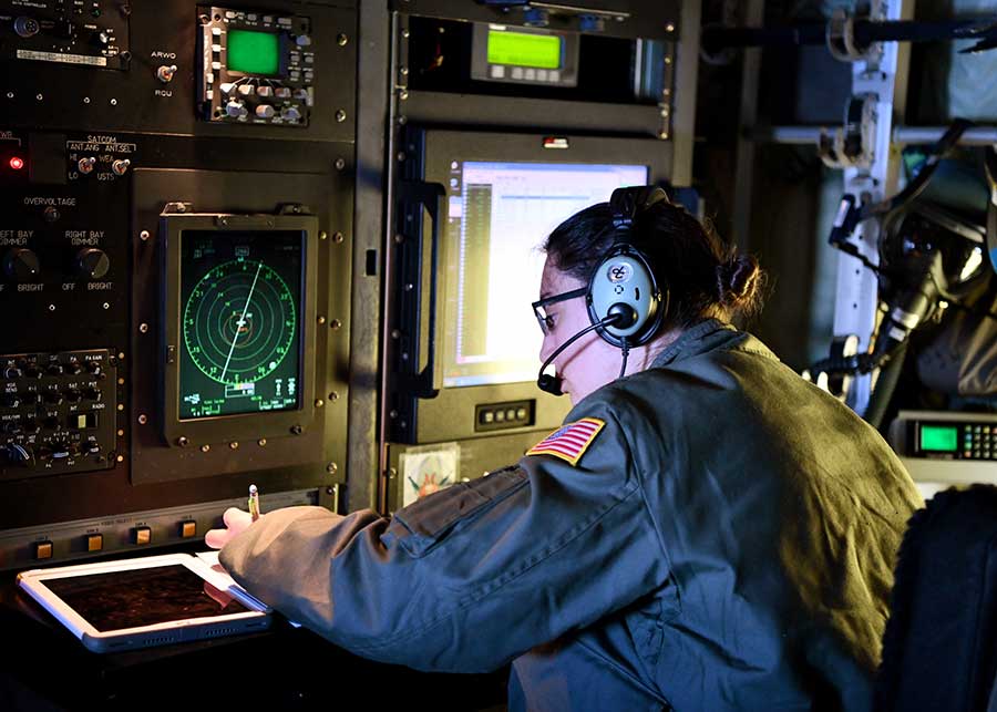 Maj. Sonia Walker, aerial weather reconnaissance officer writes down coordinates after a dropsonde deployment during a flight.