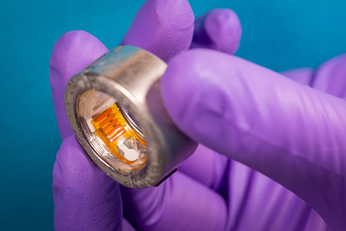 A thick metal ring with small paper and plastic parts lining the inside.