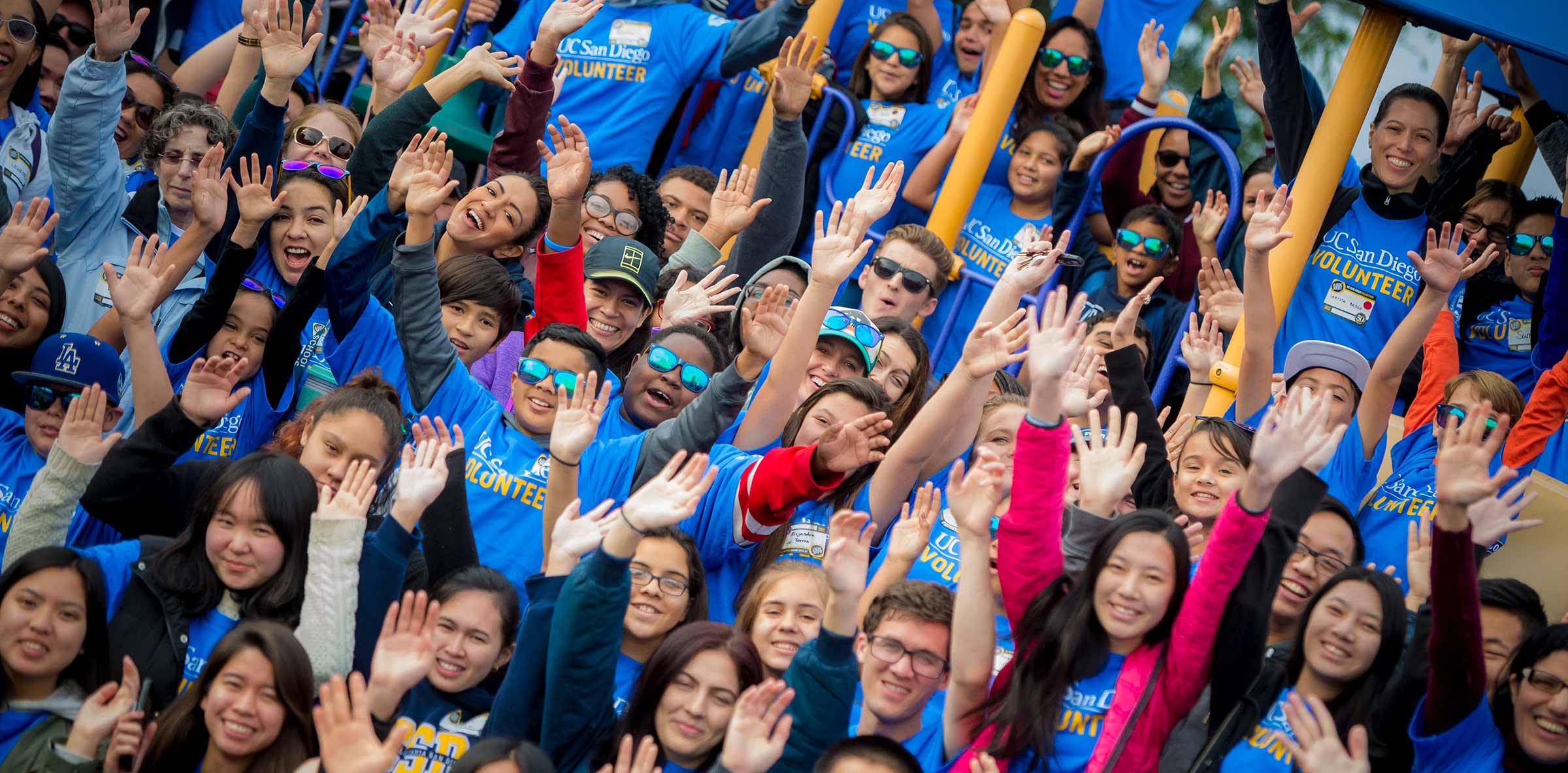 students with hands up excited about changemaker week