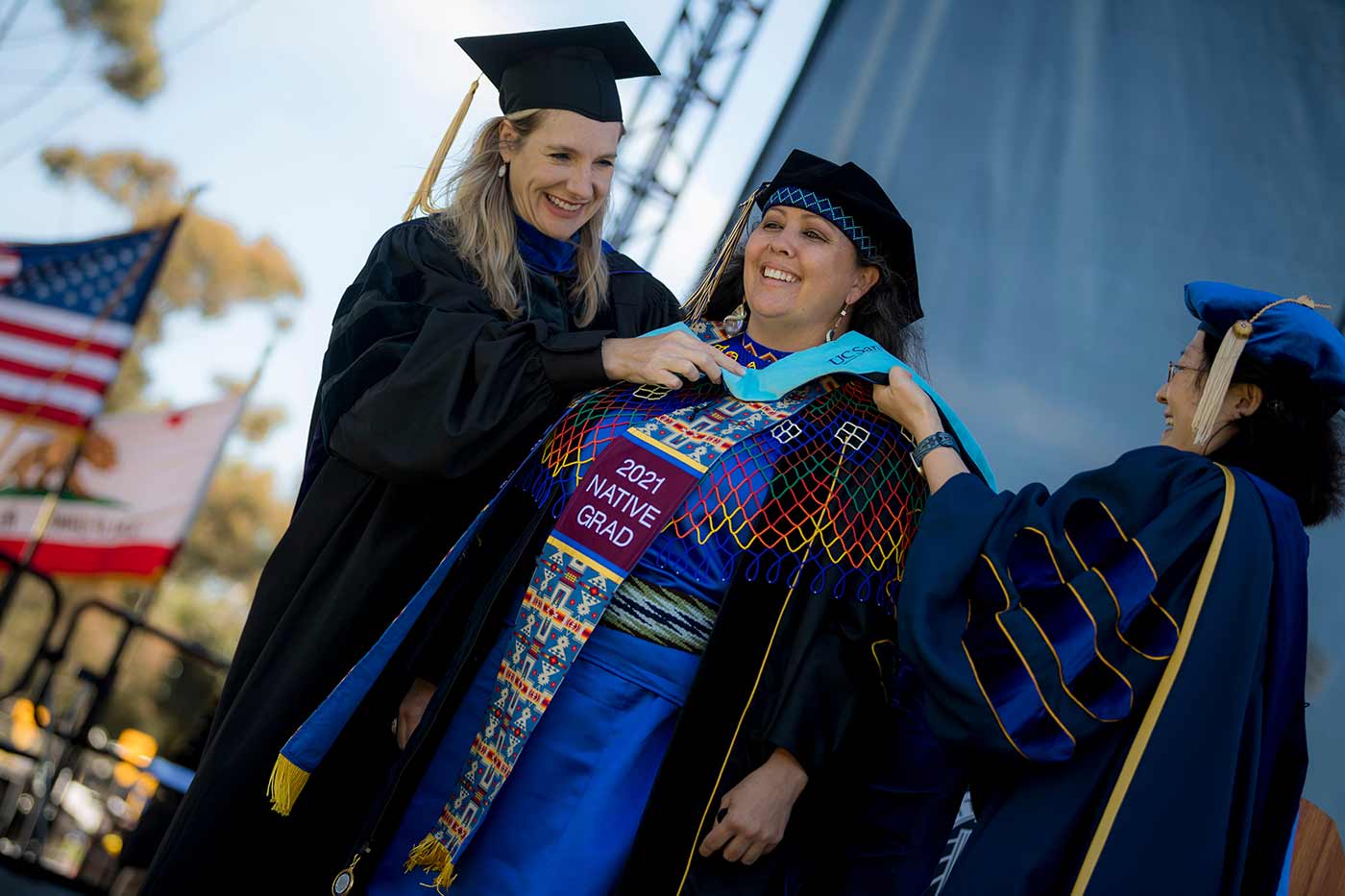 Student rejoices on stage during the Graduate Division, Doctoral and Master of Fine Arts Commencement ceremony.