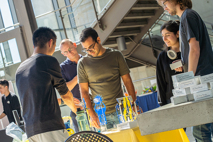 students look at a collection of projects made by a student org