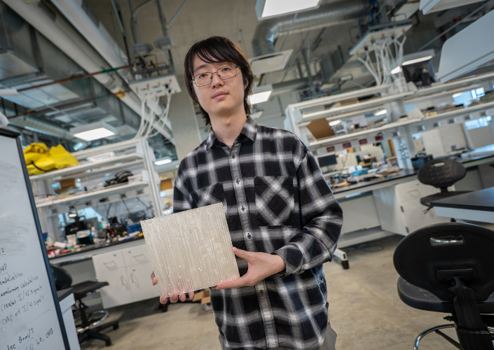 a silver tile held by someone in a lab