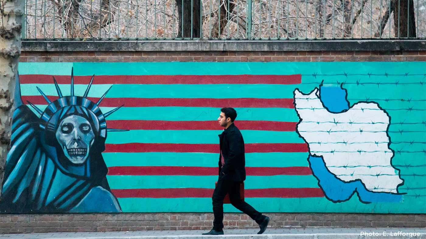 man walking in front of mural.