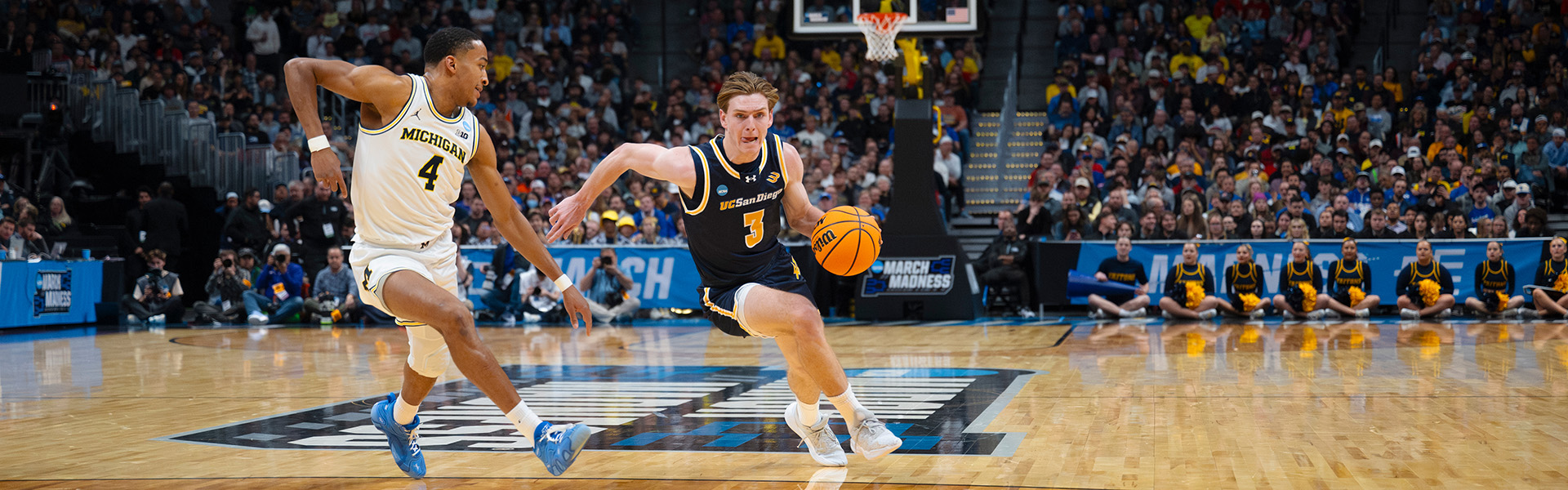 Triton basketball player wearing number 3 keeps ball from Michigan player