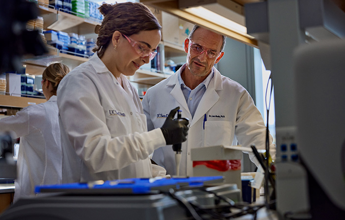 Two researchers in lab coats working in lab