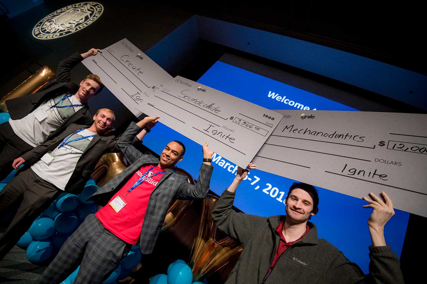 winners holding giant checks