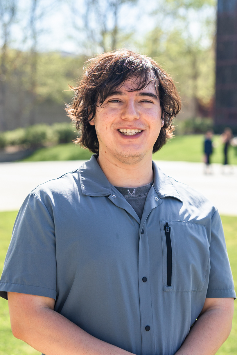 person smiling at the camera wearing a grey shirt
