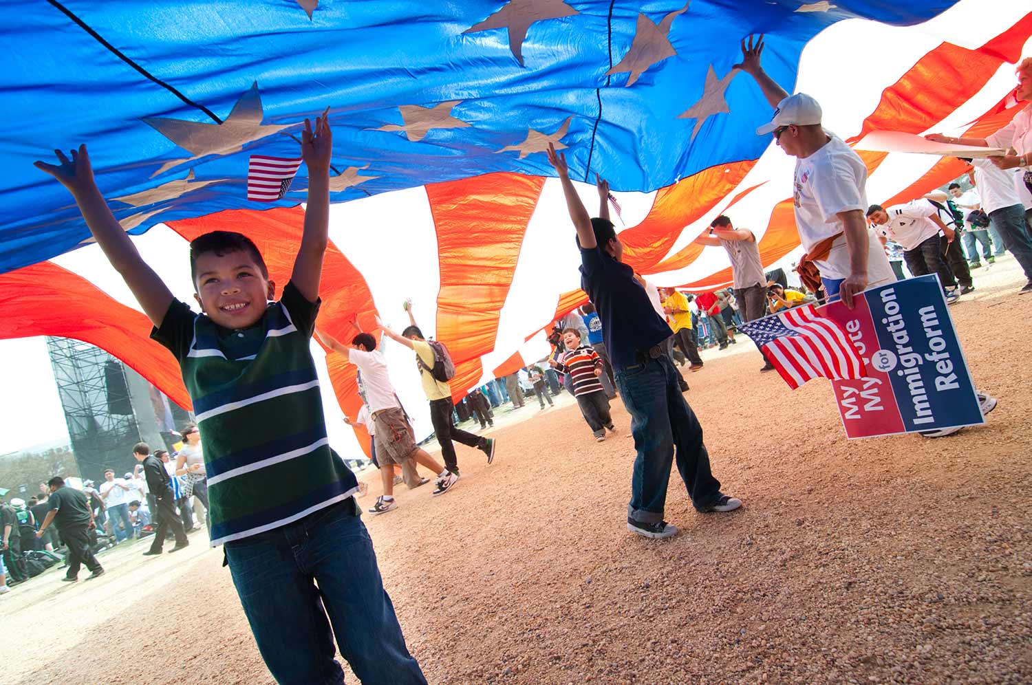 Children play under American flag at immigrant rally