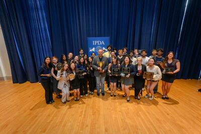 The team after the International Public Debate Association (IPDA) nationals when the team won 1st place overall. Coach Arthur “AJ” Edwards Jr. is in the center of the photo holding the trophey. 