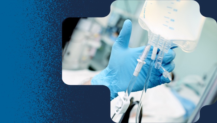 Gloved hand holds IV drip bag