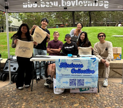 A group of students advertising their student organization on campus. A banner that says