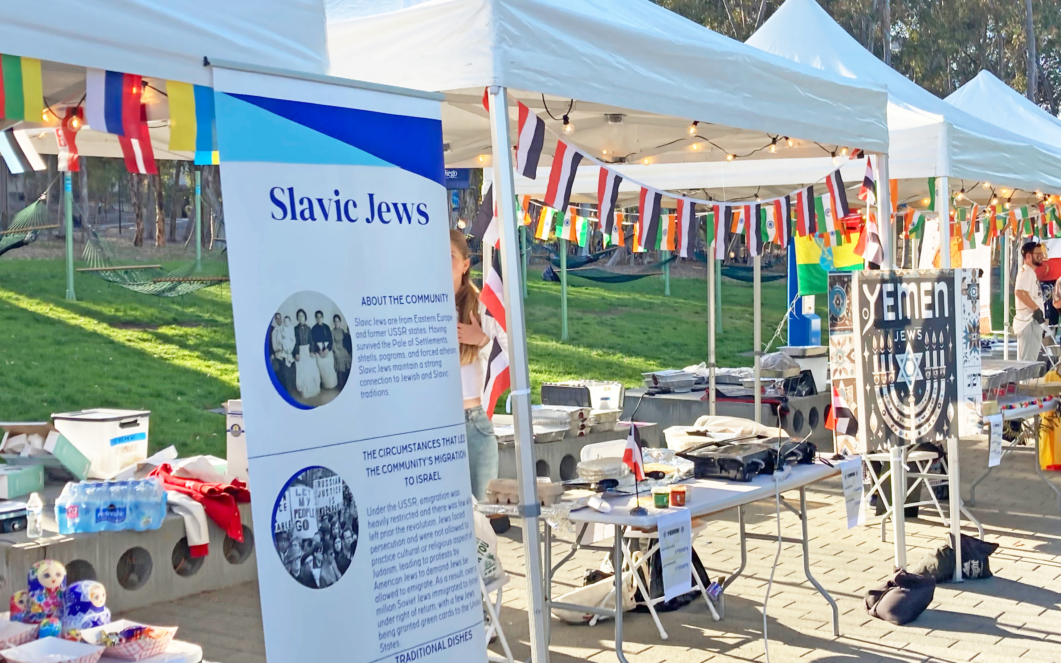 Booths with popup tents and tables with signs about Slavic and Yemeni Jews