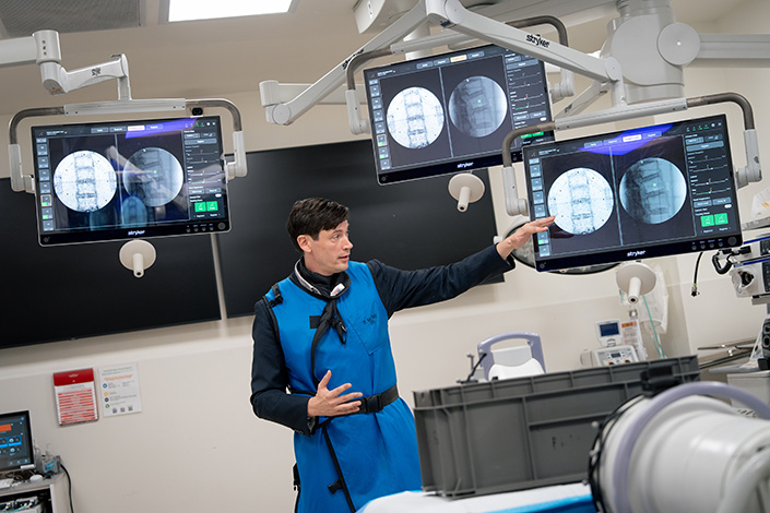albert hill in front of three screens with medical images