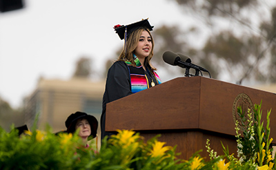 Student Commencement Speaker Letzy Vargas delivers her speech at a podium on stage.