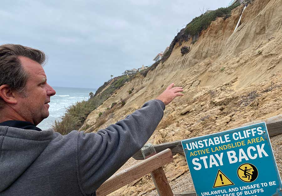 Scripps researcher Adam Young points to an area north of the beach trail showing new cracks, indicating the area was still in an active landslide in 2022.