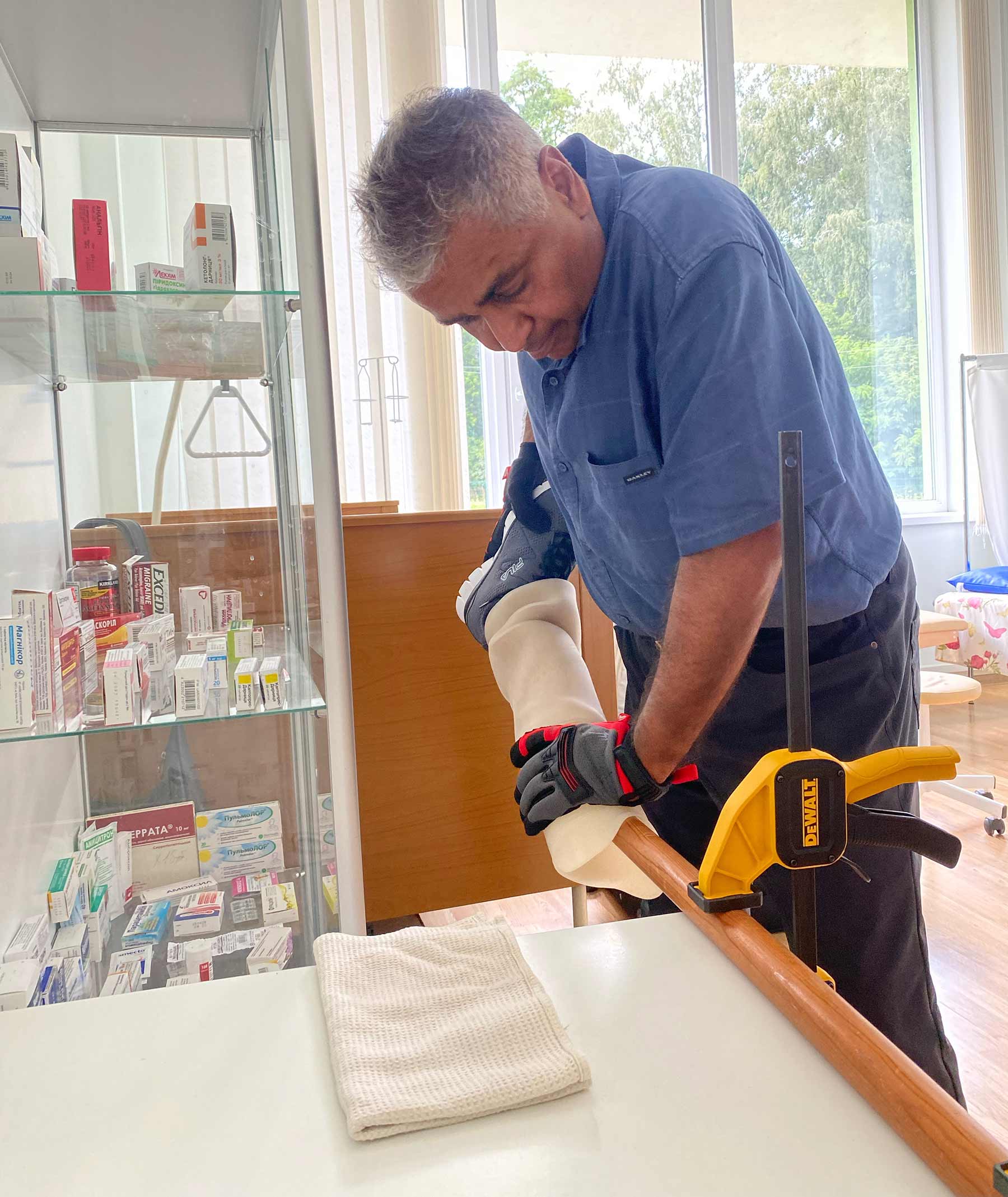 Dr. Manoj Monga making a minor adjustment to a prosthetic limb during a fitting.