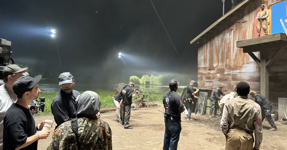 Behind the scenes of an outdoor movie set with cast and crew