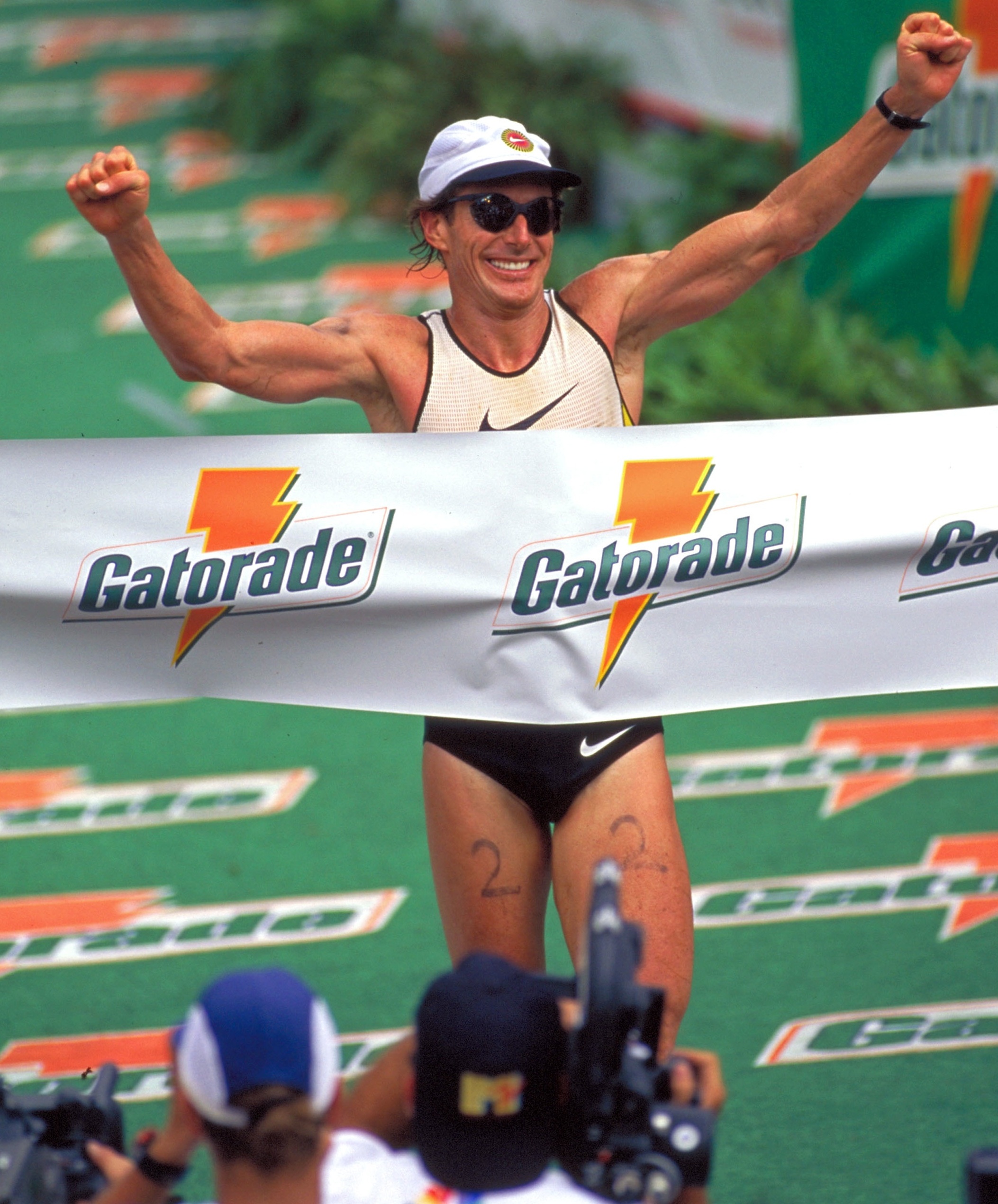 Person runs with arms raised at winning banner