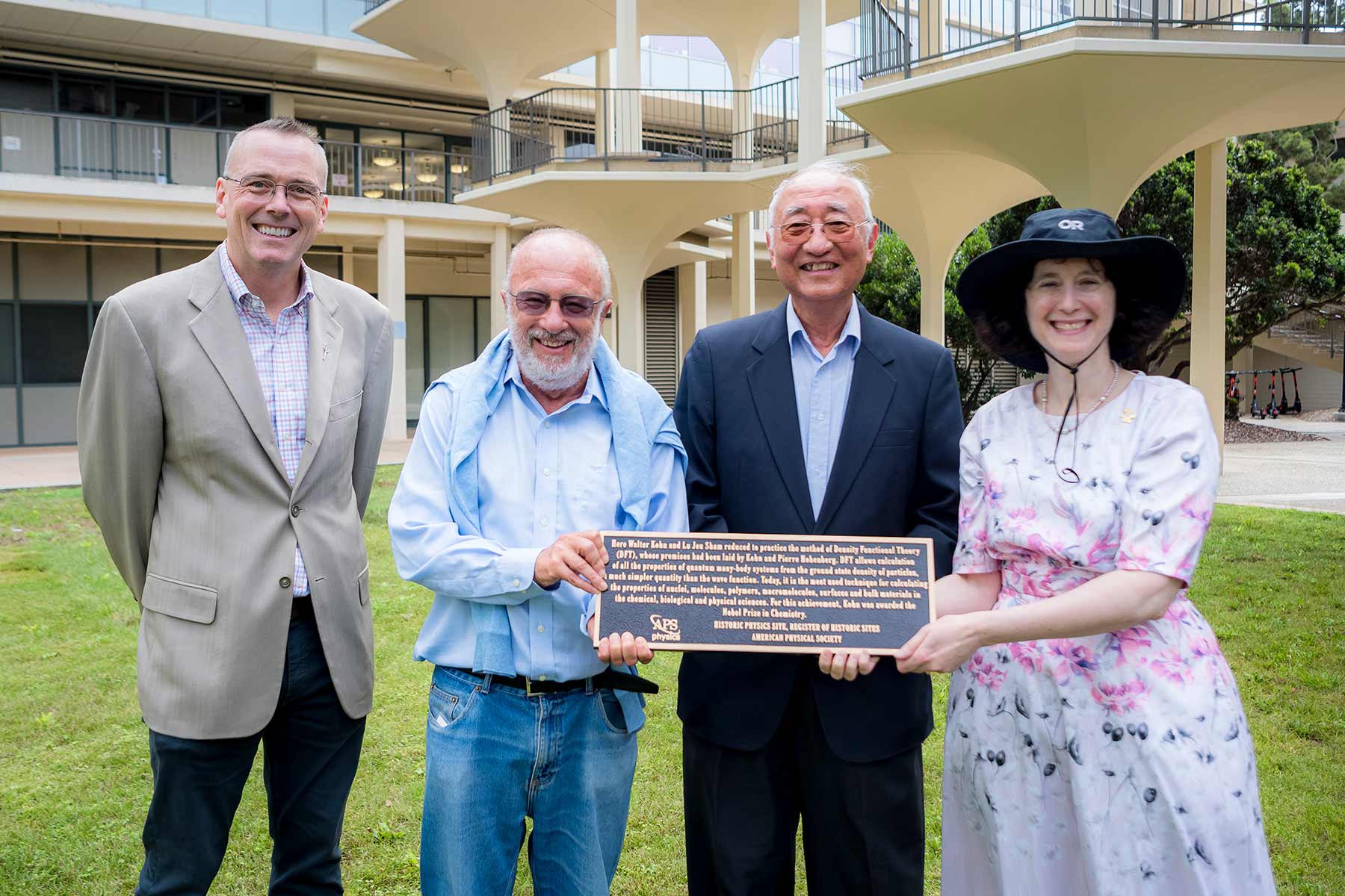 Dean Boggs, Professor Schuller, Professor Emeritus Sham and Executive Vice Chancellor Simmons hold the plaque commemorating Mayer Hall as a historic landmark.
