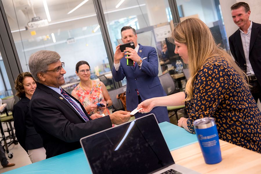 Panchanathan accepts a business card from Kim Pendergrass, a UC San Diego MBA graduate and co-founder of Algeon Materials.