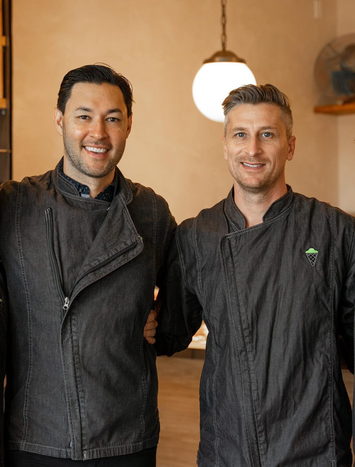 Two men stand side-by-side in a room.