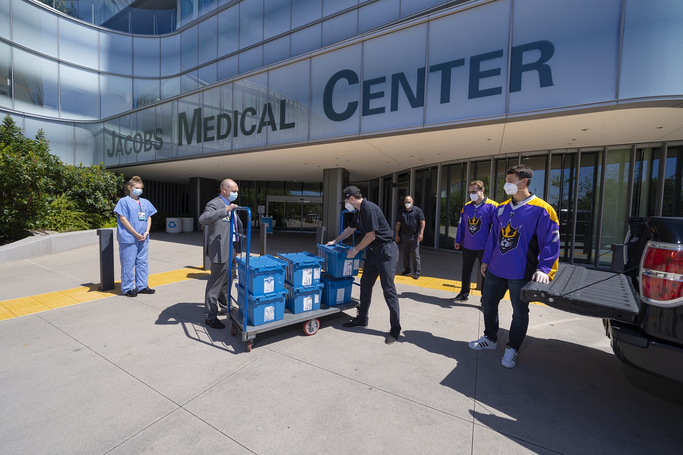 Hospital employees and lacrosse players moving supplies