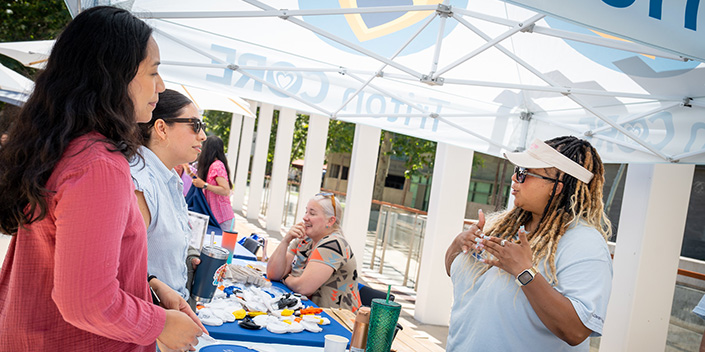 Two staff members talk with Triton CORE representative