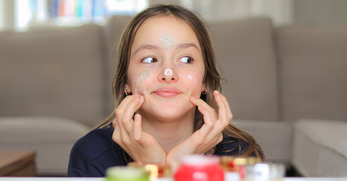 Kid puts multiple face products on skin