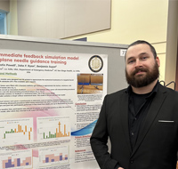 Medical student, Austin Powell standing next to research poster.