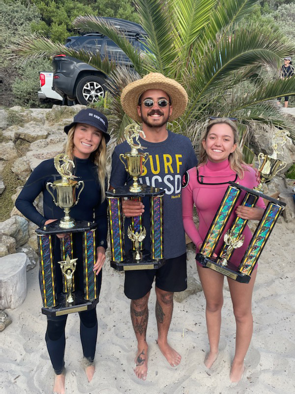 Makena Burke holds her trophy alongside fellow student surfers at a surfing competition.