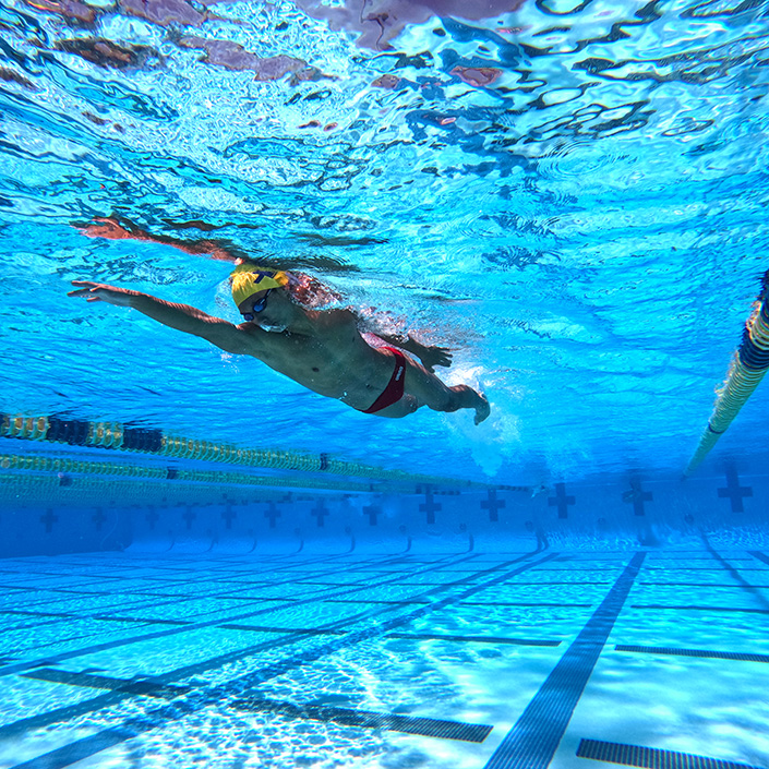 Underwater photo shows student in swim cap swimming laps