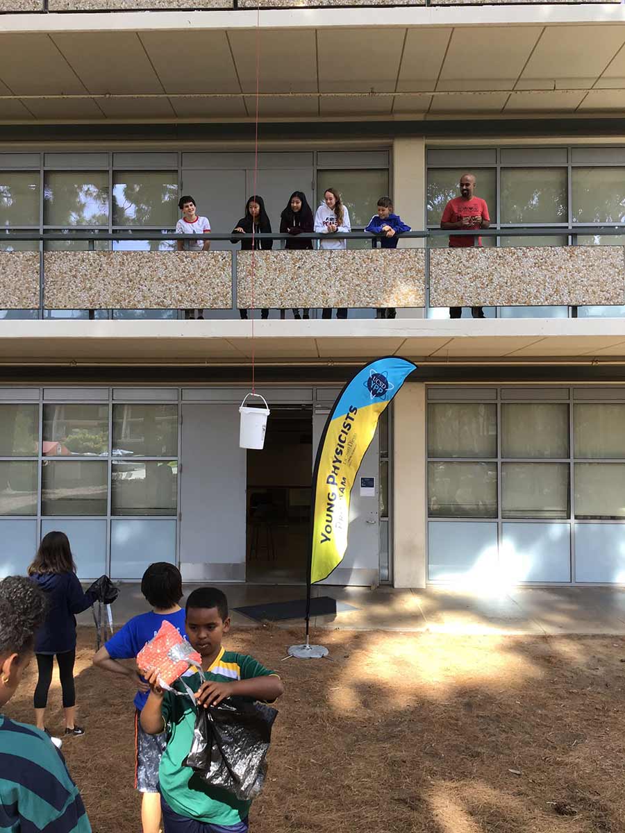 students on field with egg parachute