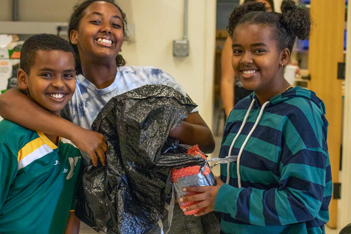 three students working on egg parachute