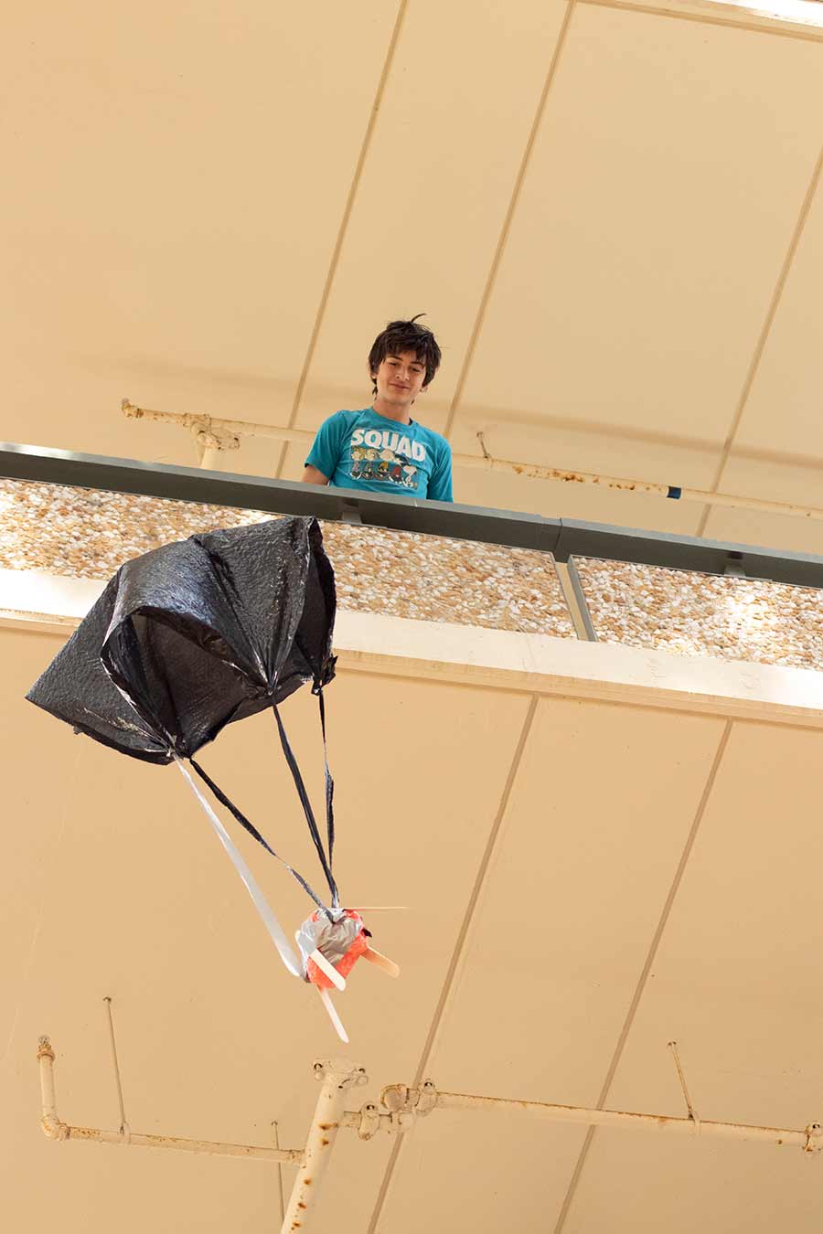 student dropping egg parachute