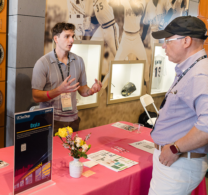 Tom Molley talks with attendee from behind OxyLo exhibit table