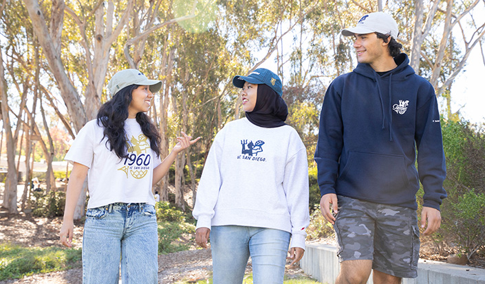 Three individuals walk down sidewalk wearing Triton Legacy Collection gear