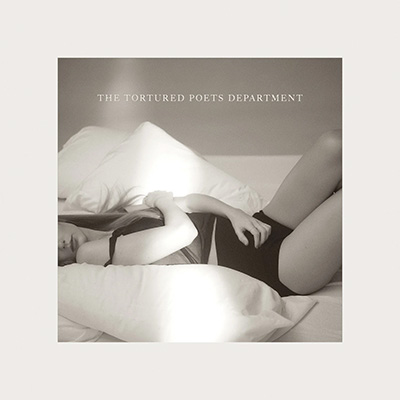 Taylor Swift laying on pillows in black and white The Tortured Poets Department album cover