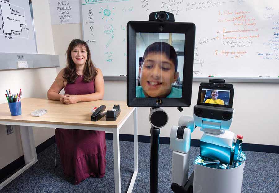 UC Irvine researcher Veronica Newhart with two of the telepresence robots.