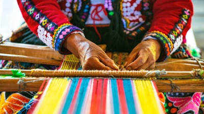 Individual hand weaving a piece of art