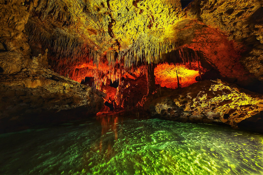 Photo showing a cave lit in green and orange. Photo by Fabio Esteban Amador.