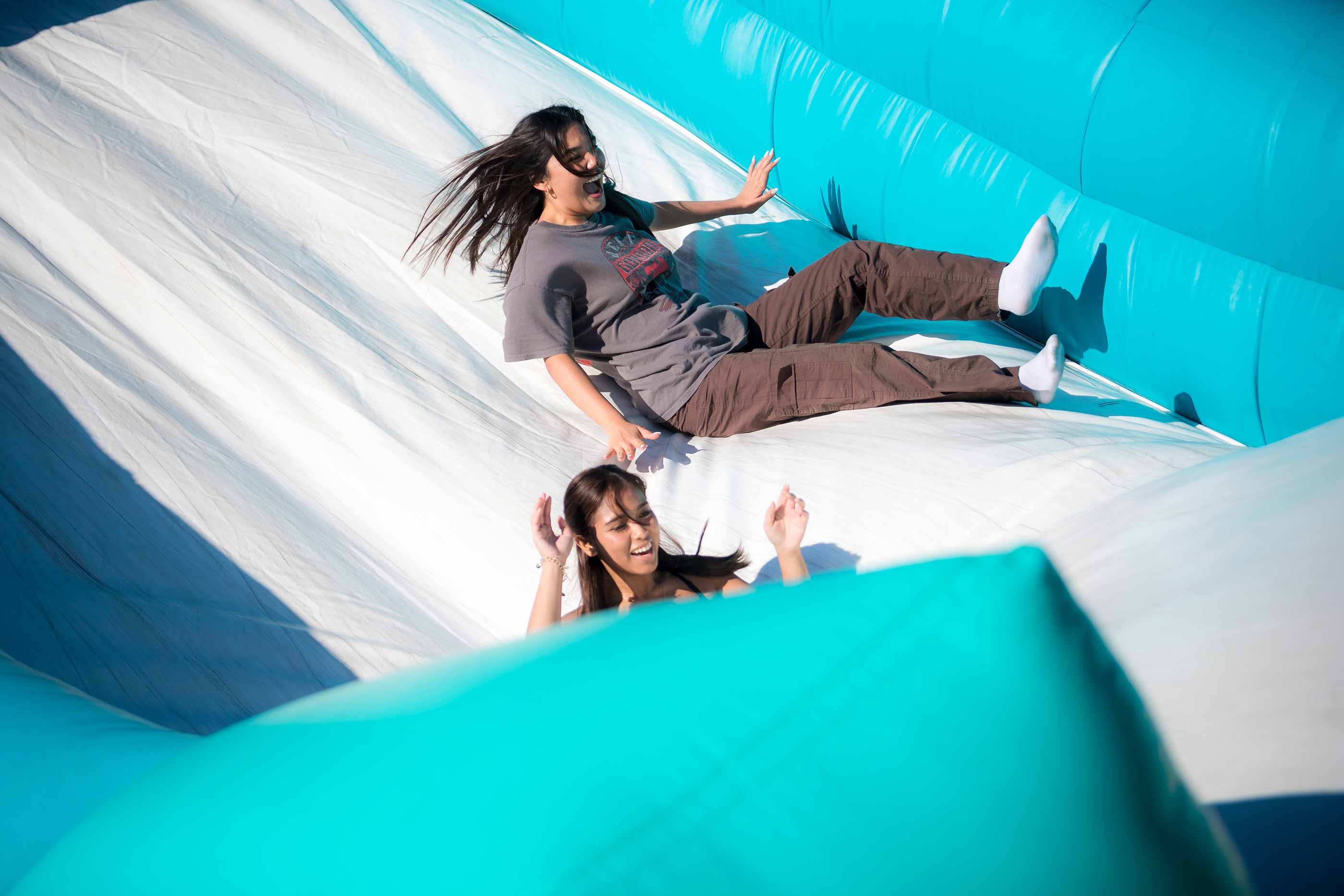 Students go down inflatable slide.