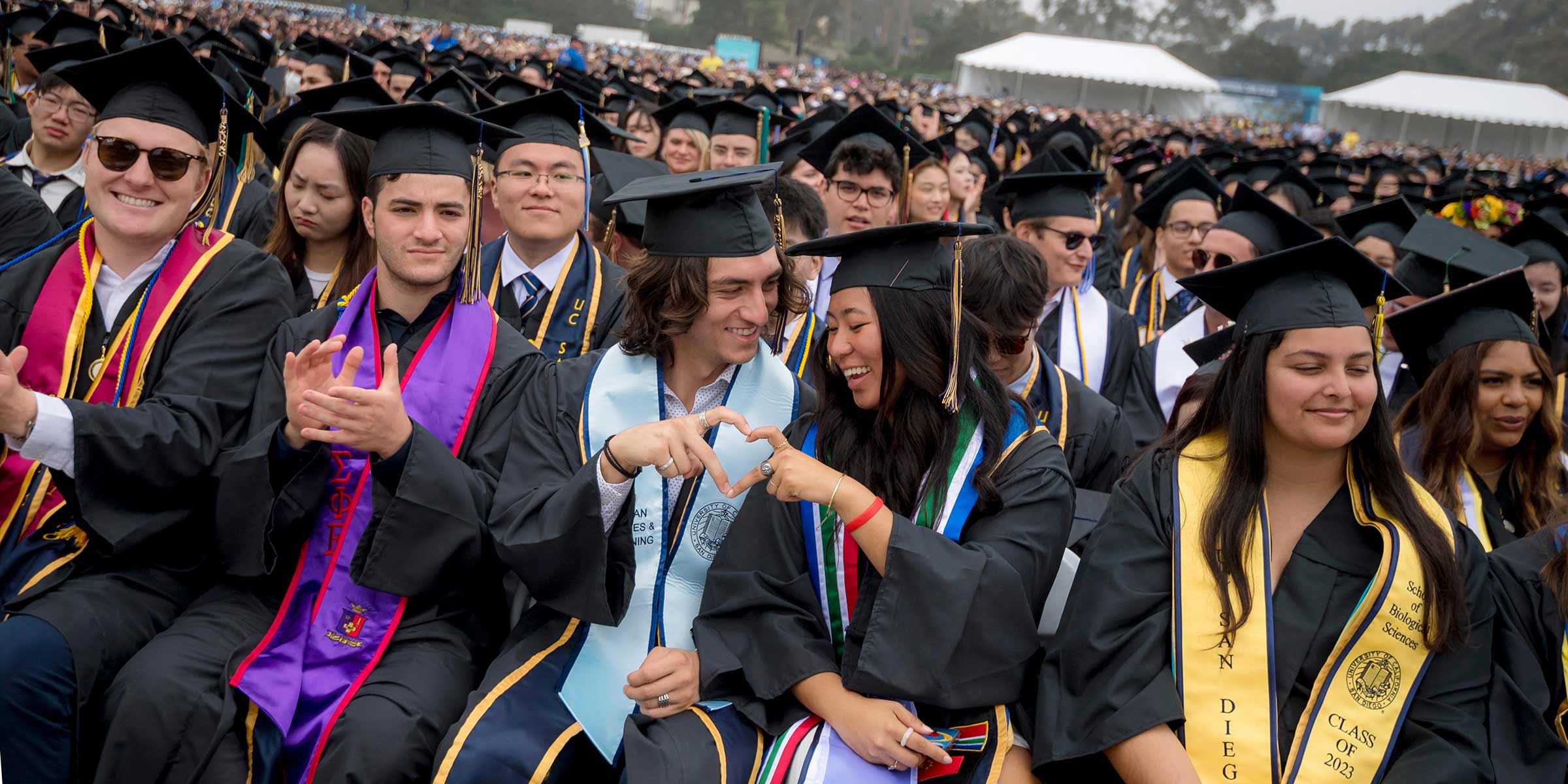 Students form a heart during the All Campus Commencement