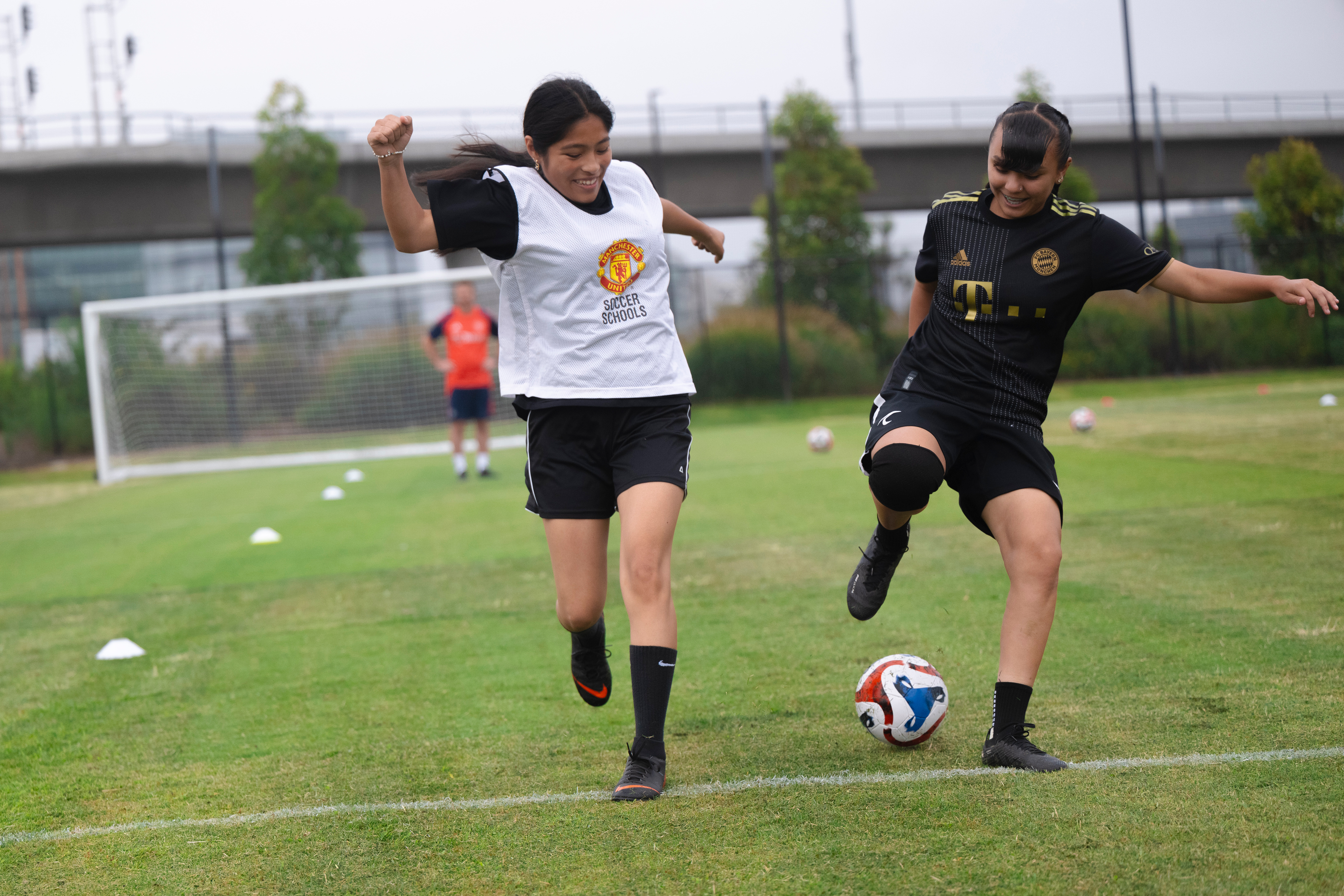 Two soccer players battle for ball
