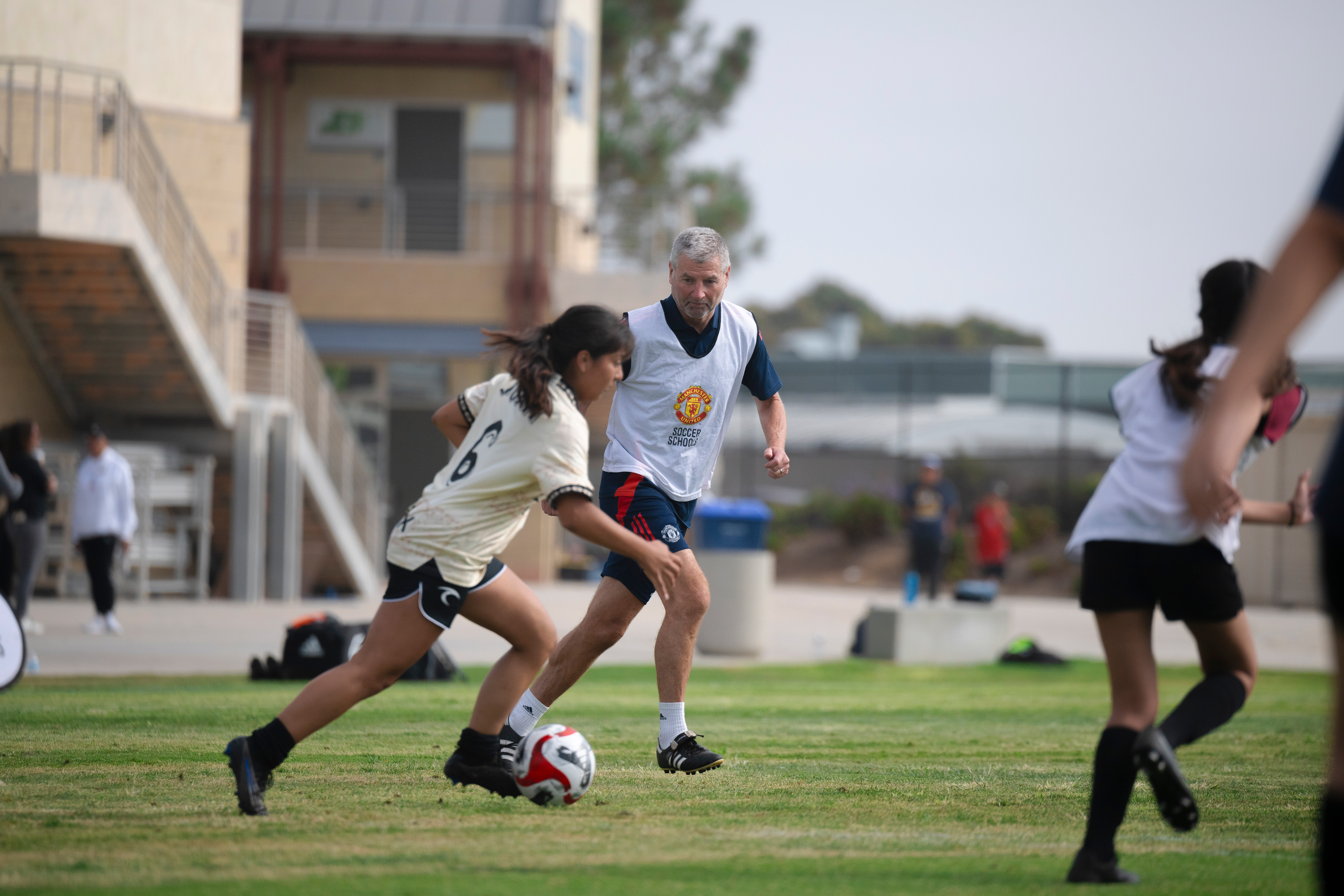 Manchester United legend Denis Irwin runs alongside high school soccer player