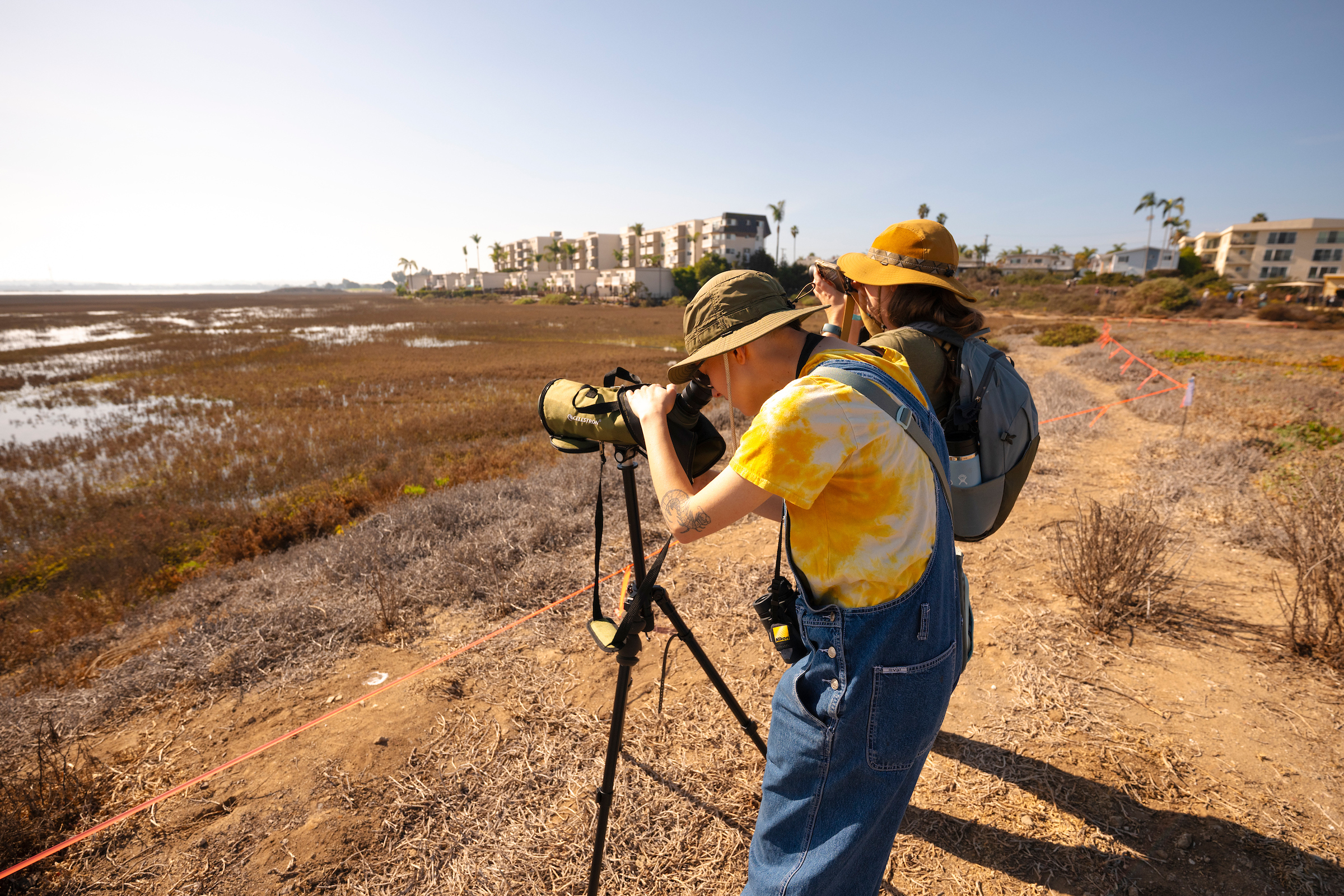 Two people looking through binoculars