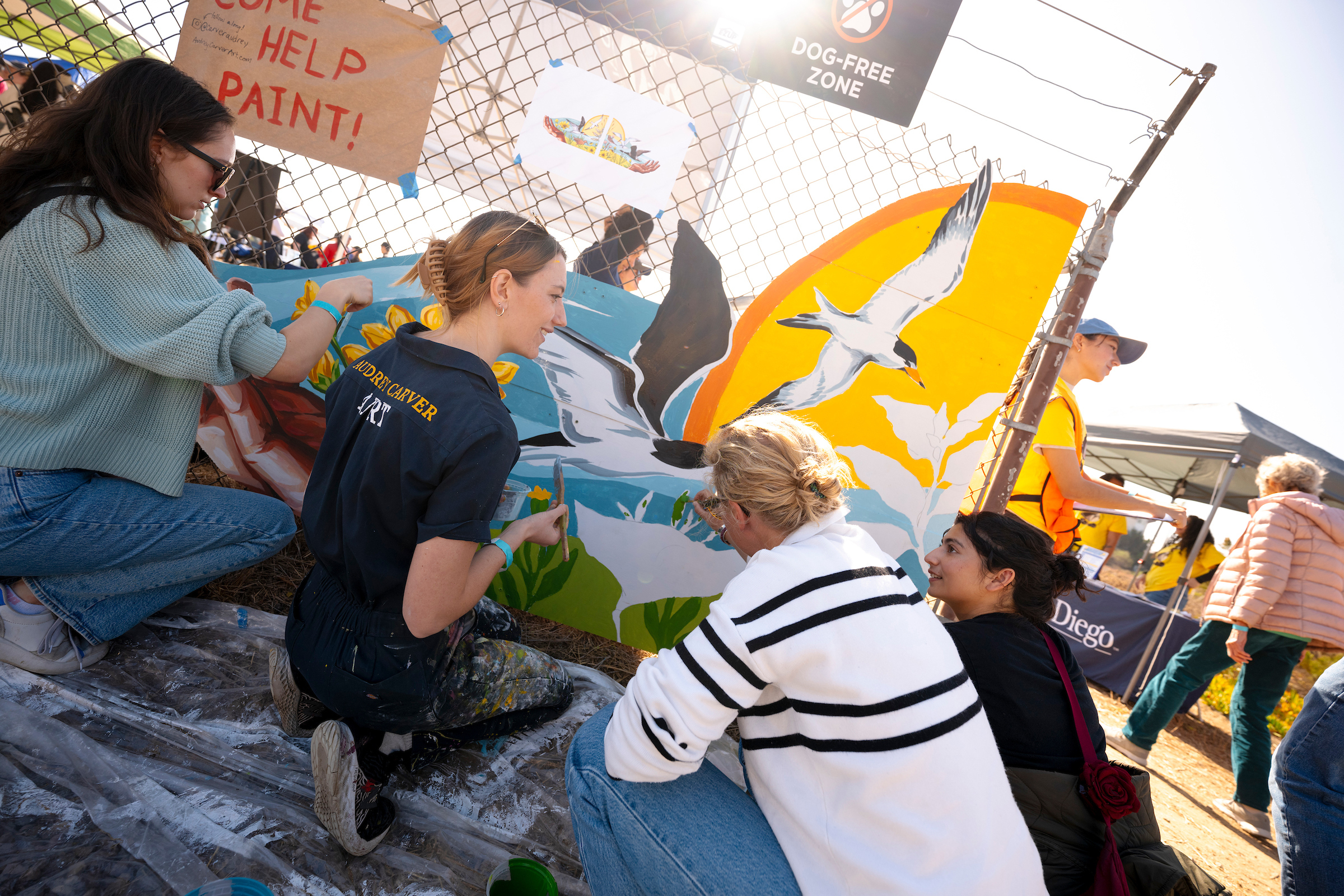 Volunteers paint mural at event.