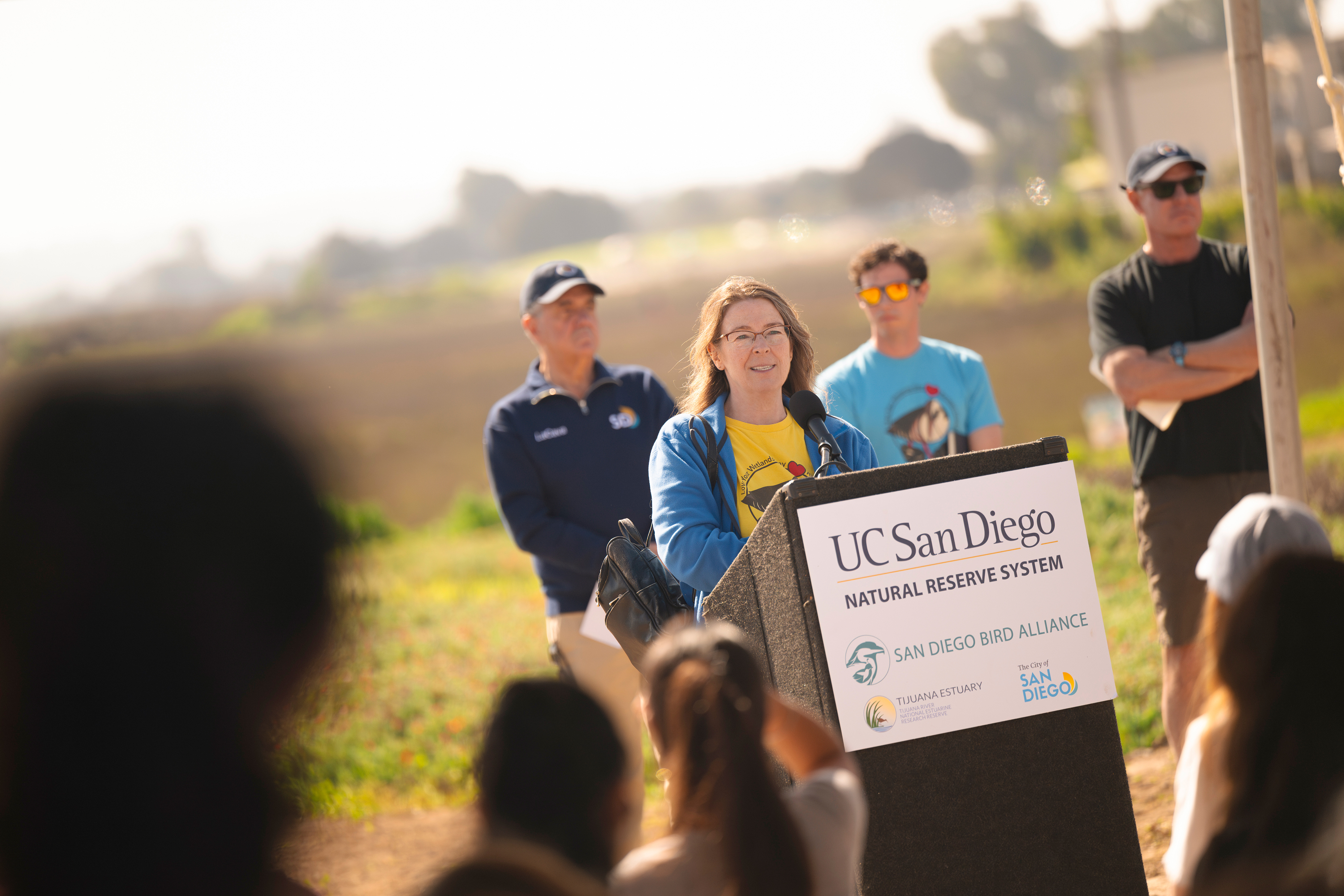 Woman stands at podium delivering speech.