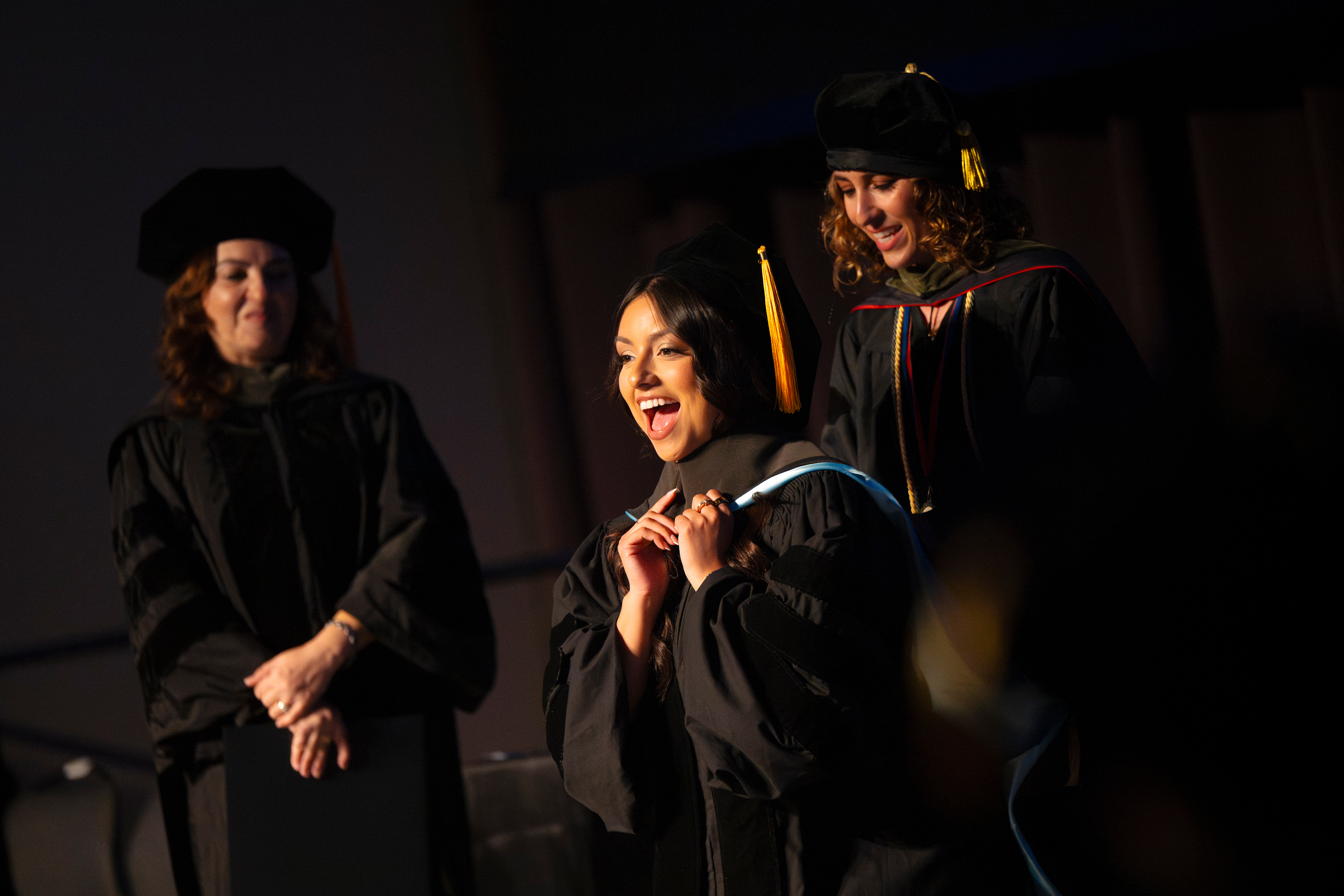 Female student on stage happy.