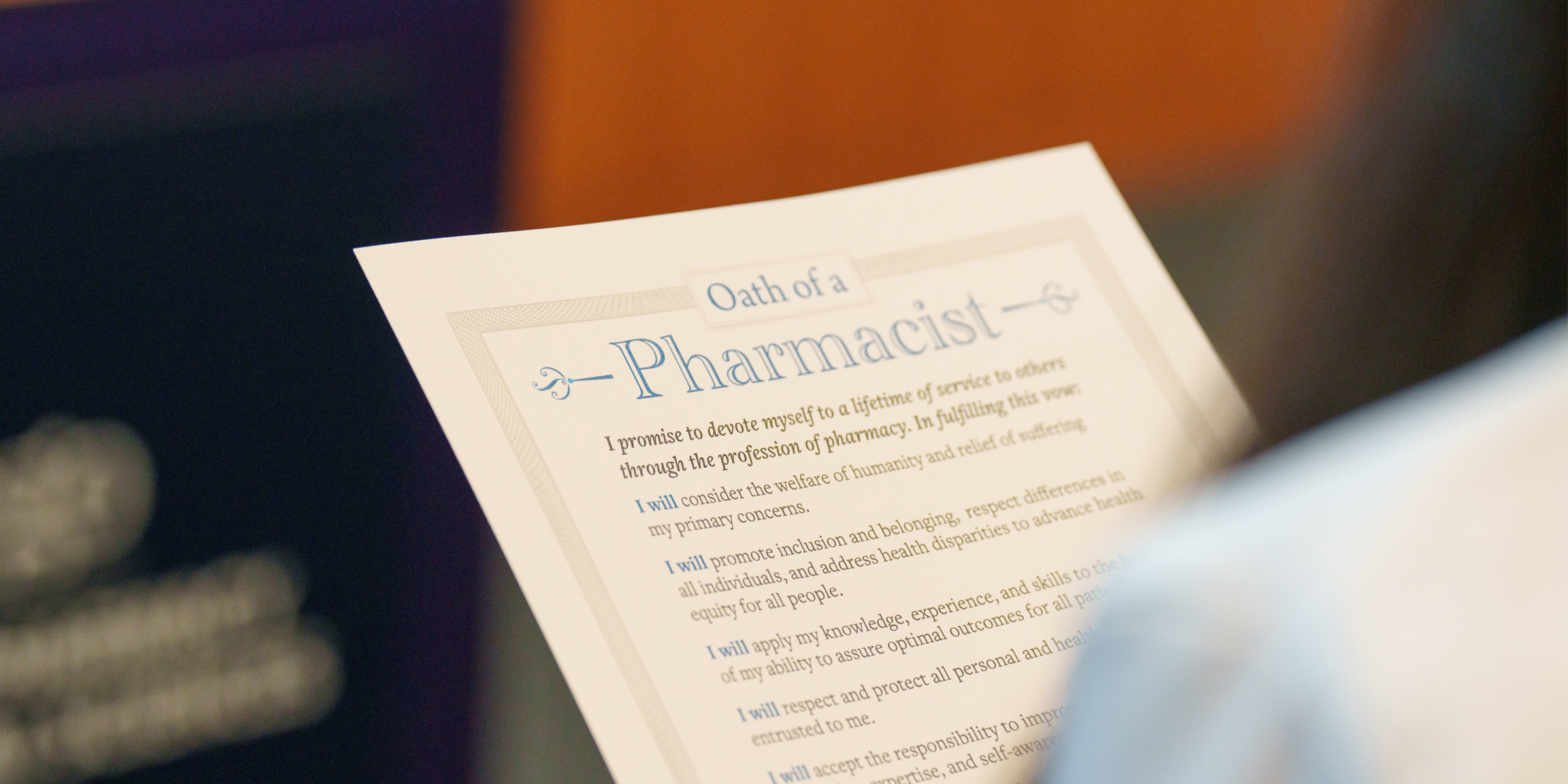 Person holding paper that says Oath of a Pharmacist.